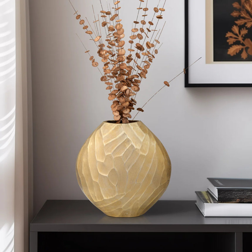 Still life of vase filled with dried floral arrangement.