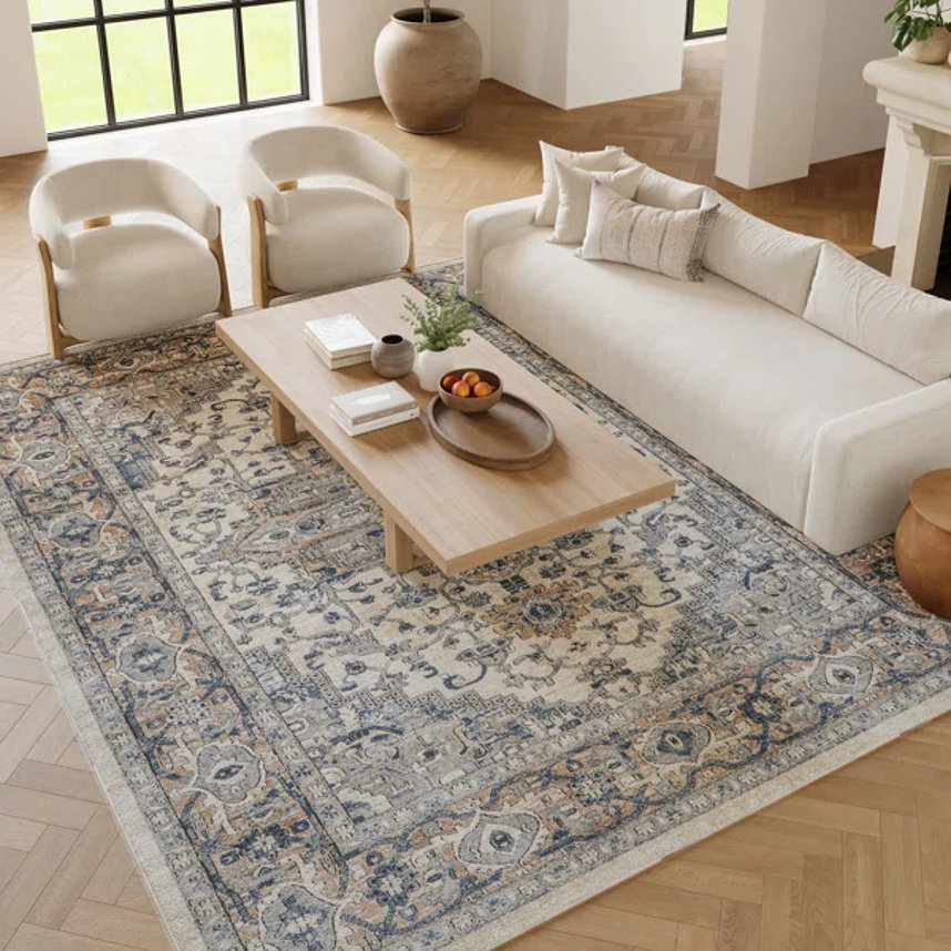 Living room with oriental-style rug, sofa, chairs, and coffee table
