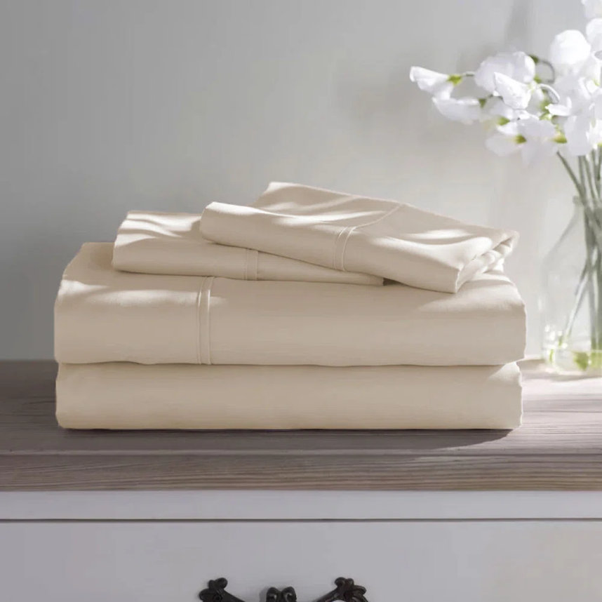 Folded set of tan-colored sheets on a dresser.