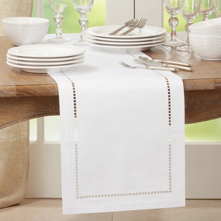 Table setting with white runner and place settings.