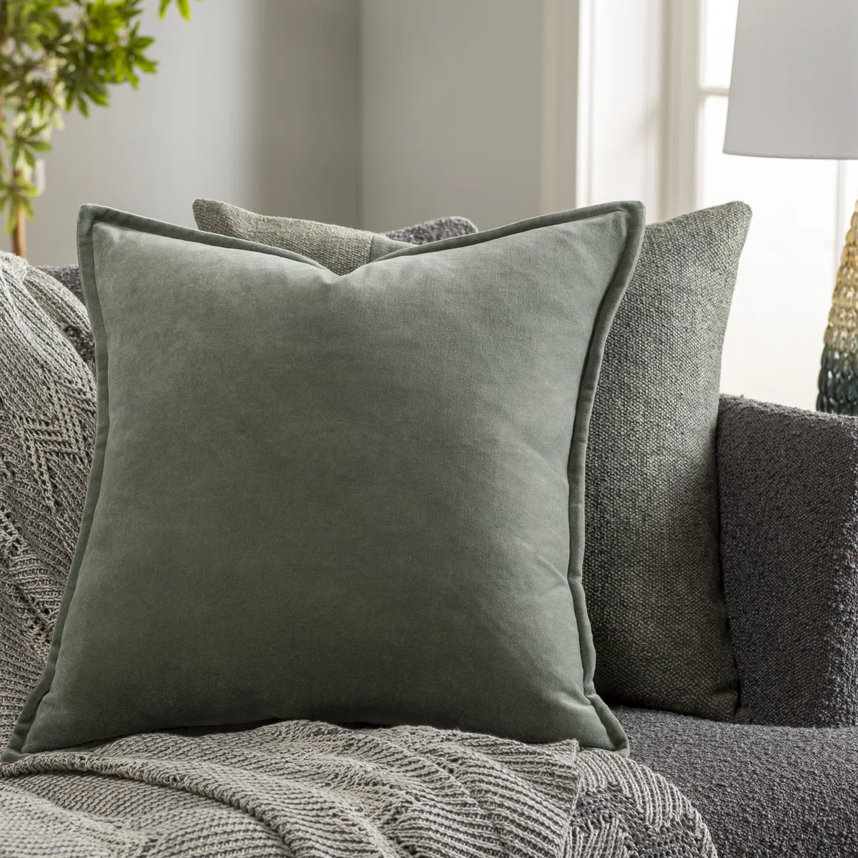Throw pillows with patterned textures and a blanket on a couch.