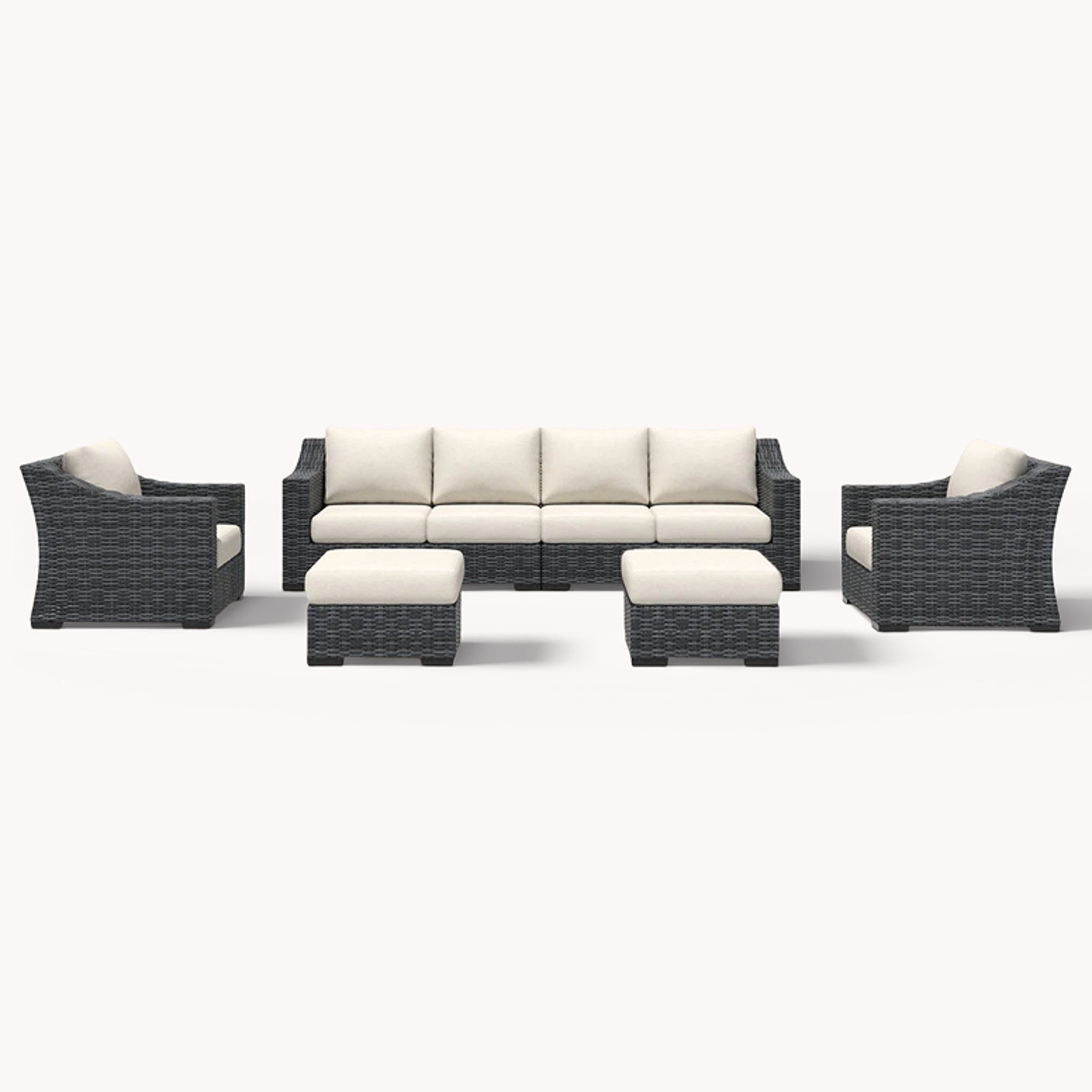 Large wicker sectional with cream cushions, ottomans, and club chairs